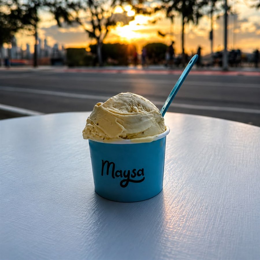 Copo de gelato Maysa numa mesa, com o pôr do sol de Balneário Camboriú ao fundo